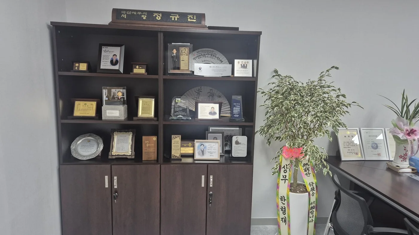 정규진 대표세무사의 상패와 경력 자료가 전시된 세무회계 정규 사무실